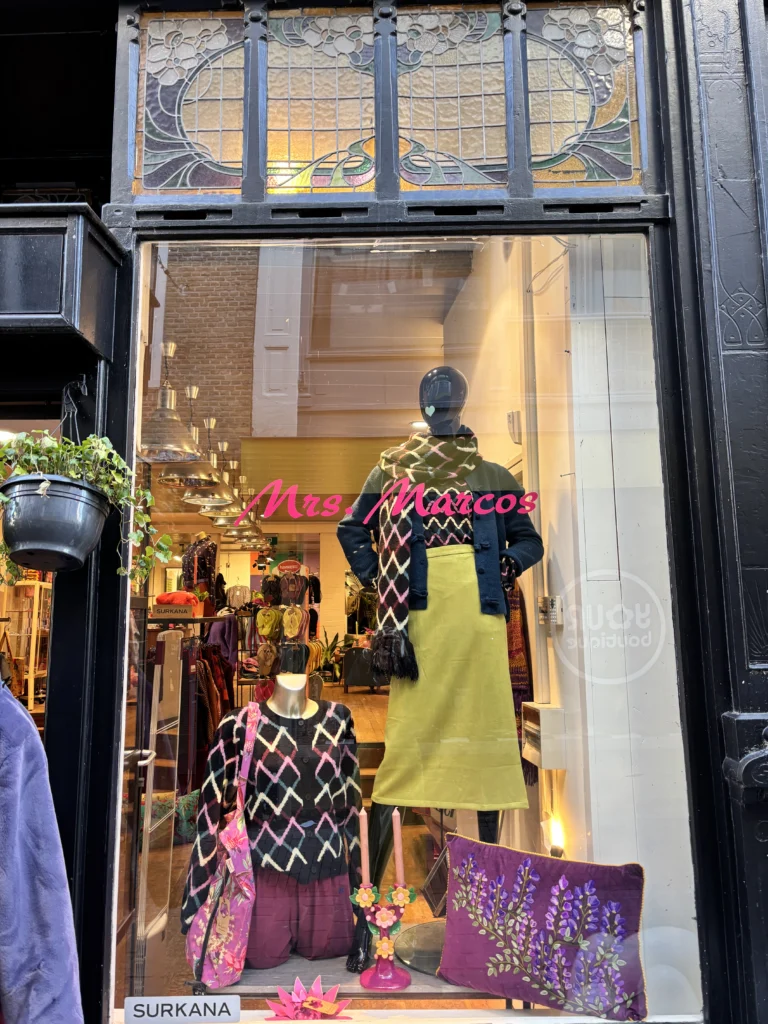 Etalage van Mrs. Marcos met een limegroene rok en een paarse tas