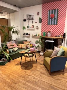 Zithoek in de winkel met een groene bank, fauteuils en planten