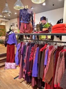 Rekken met kleding in paars, rood en bruin in de winkel